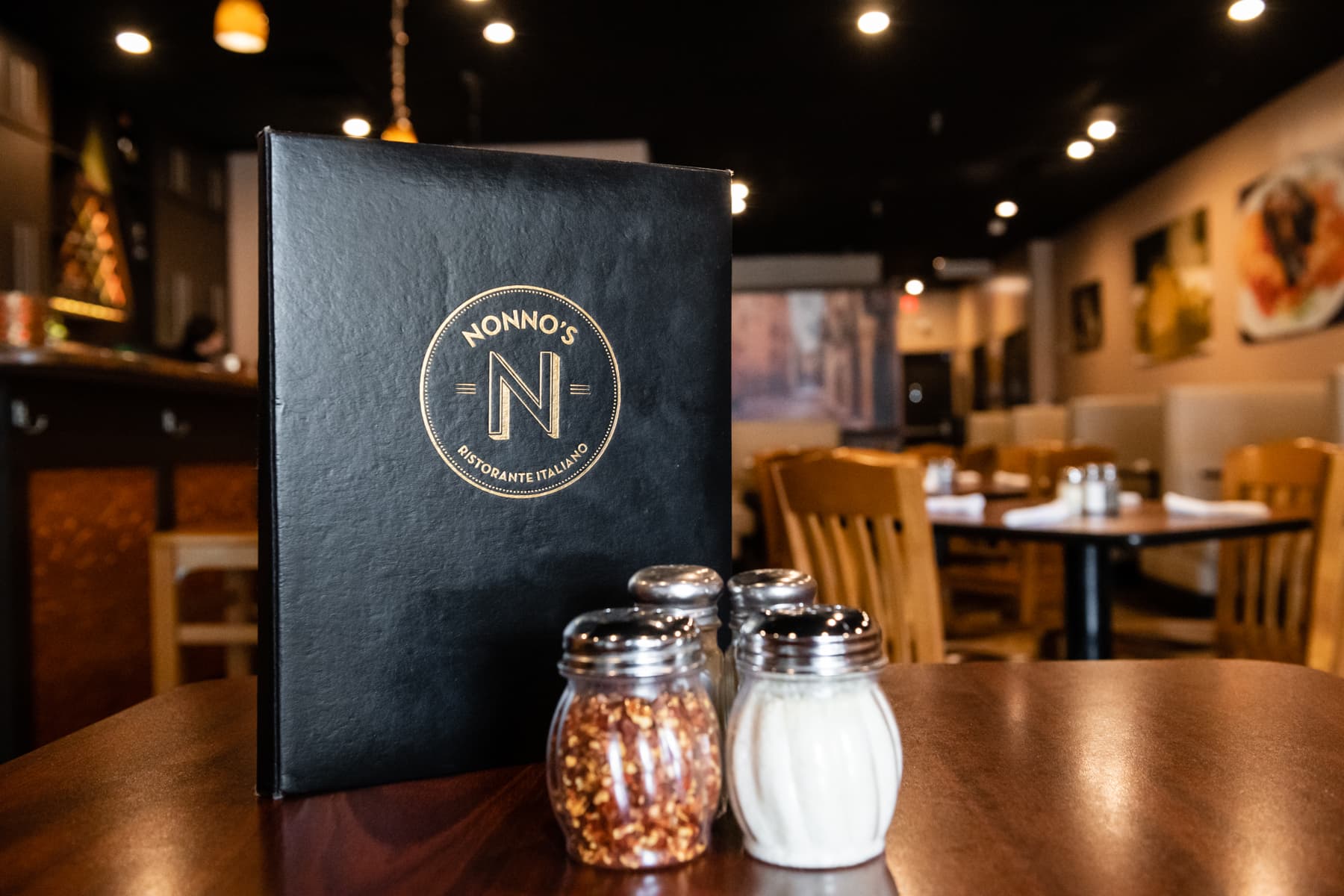 Nonno's Italian Restaurant dining room with branded menu on a table