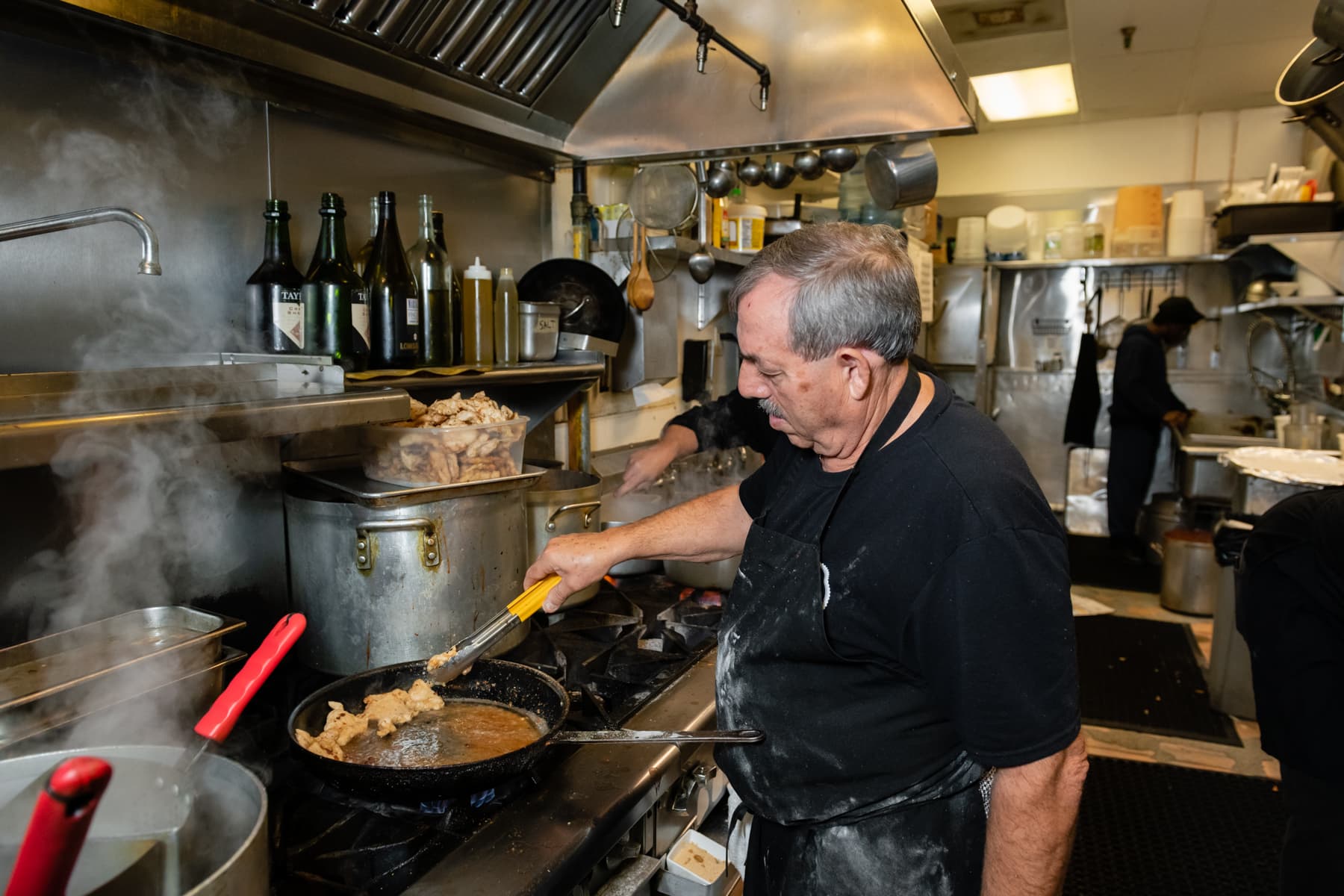 Stefano cooking at the stove in the Nonno's kitchen